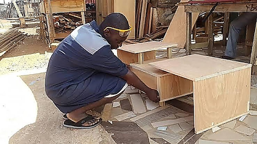 Carpenter assembling a plywood cabinet unit on site