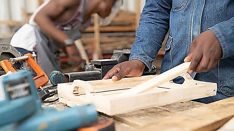 Carpentry team assembling a timber frame on the workshop bench