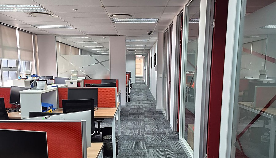 Completed office corridor with glass partitions and drywall offices finished by Africa Singatha Construction
