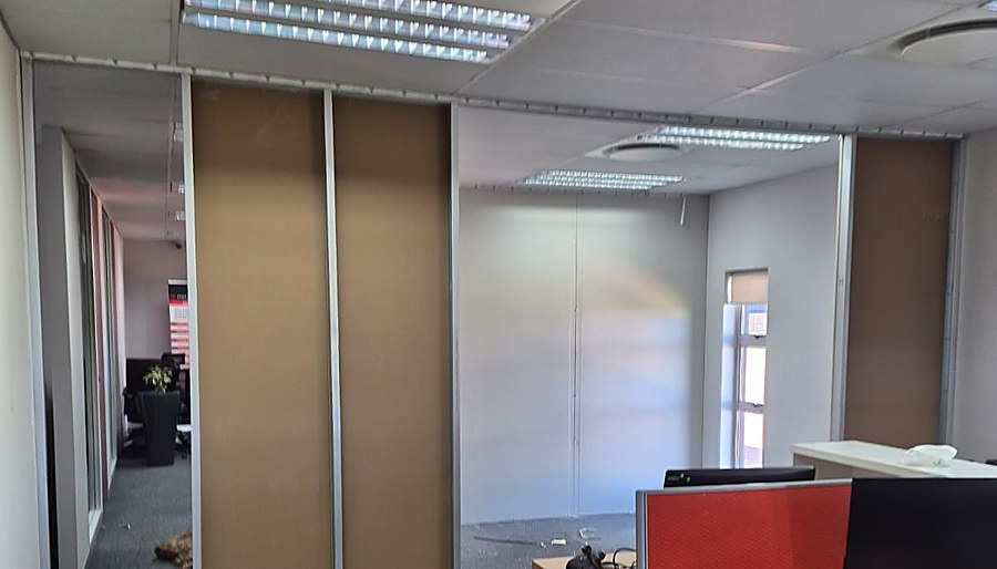 Sliding drywall office partitions and frosted glass wall in an open-plan office