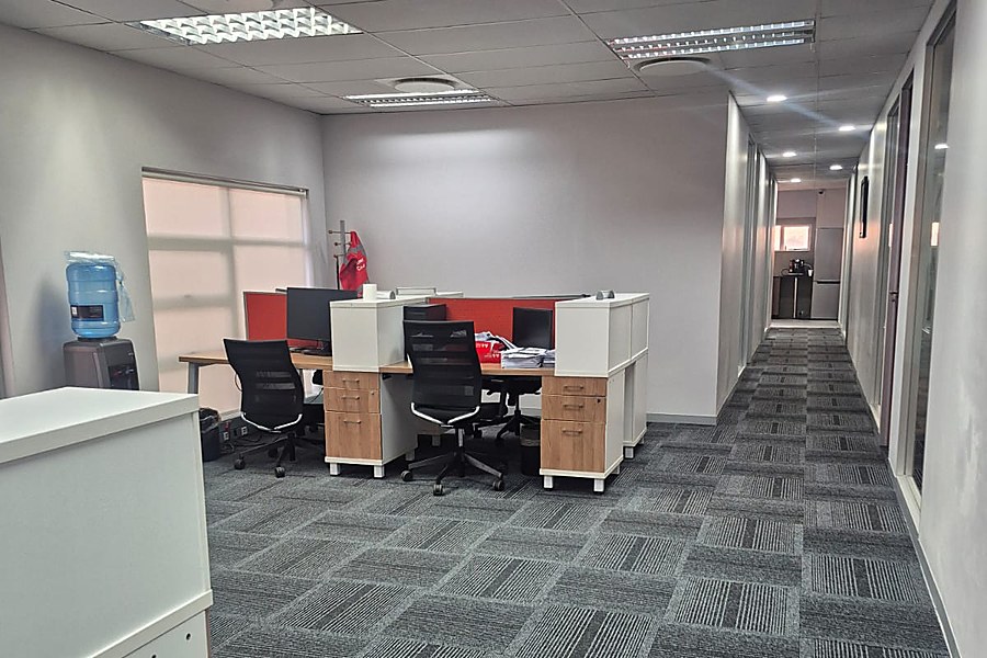 Finished open-plan office desk area with corridor to meeting rooms