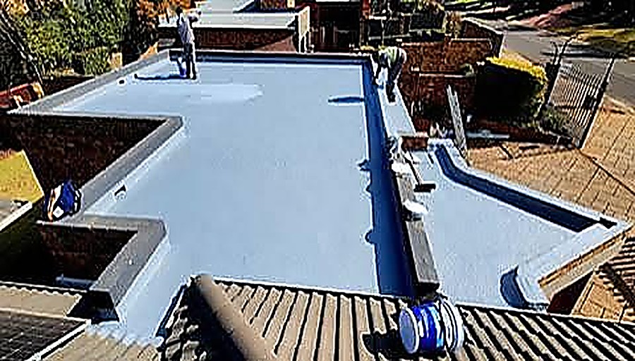 Completed flat roof waterproofing membrane in light blue coating