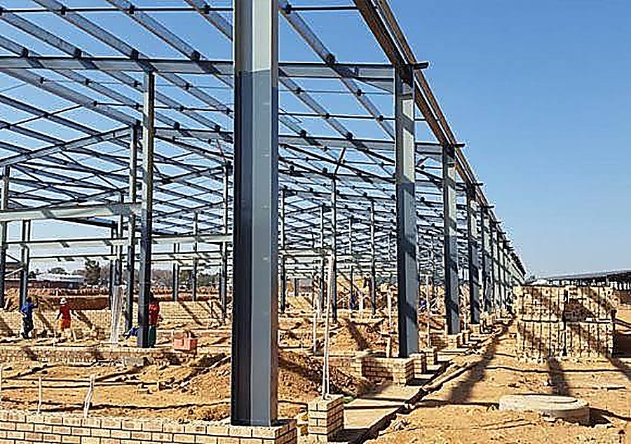 Steel structural frame erected on an industrial building site at dusk