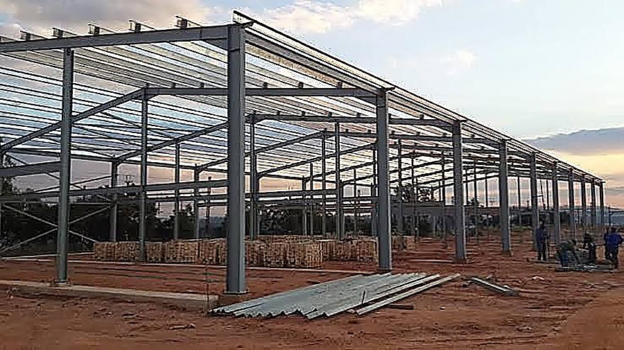 Steel structural frame erected on an industrial building site at dusk