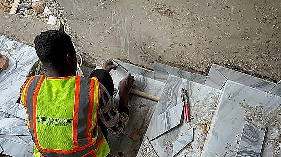 Marble tile being cut and fitted on site by a tiling contractor
